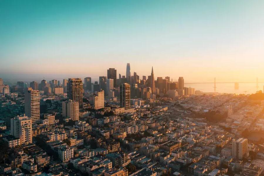 The skyline of 贝博体彩app is seen from the air in a golden light.