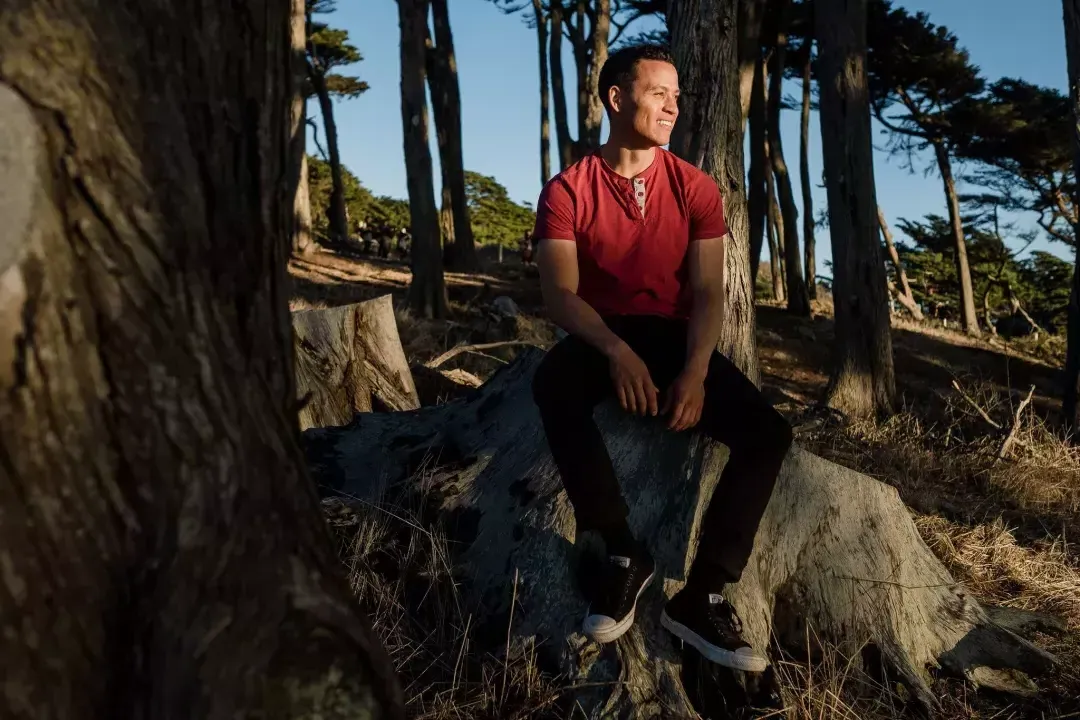 尼克Whittlesey sitting on a tree stump.