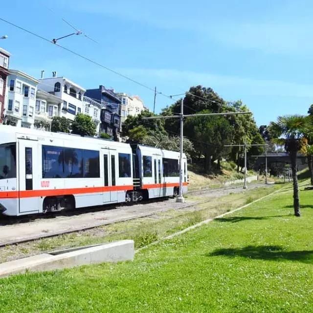 MUNI 旅客列車がサンフランシスコの線路に沿って走っています。