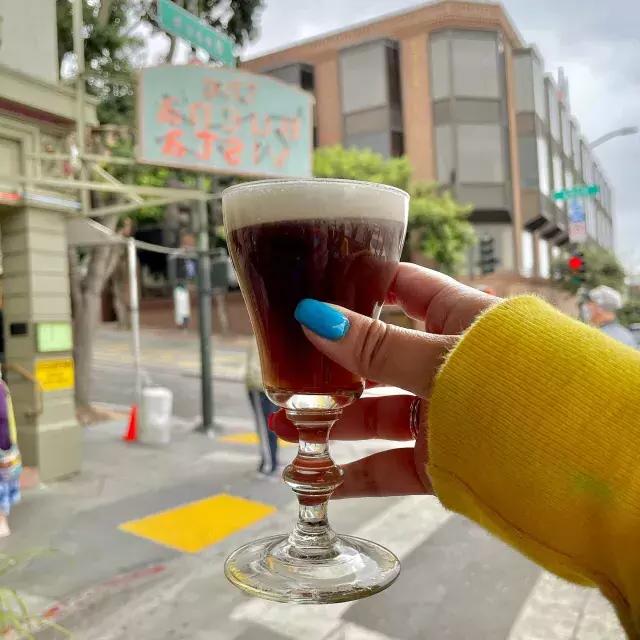 A visitor enjoys an Irish coffee outside 的 famous Buena Vista Cafe