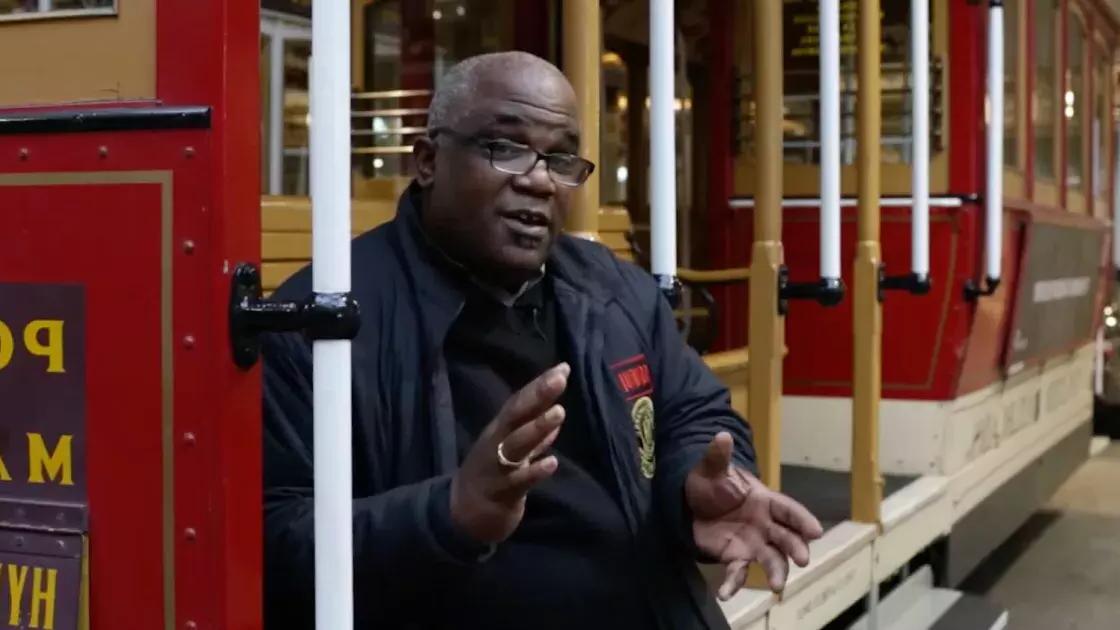 Ellis Cato sitting on a cable car.